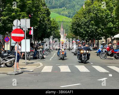 Molti motociclisti percorrono la strada principale della città in estate Foto Stock
