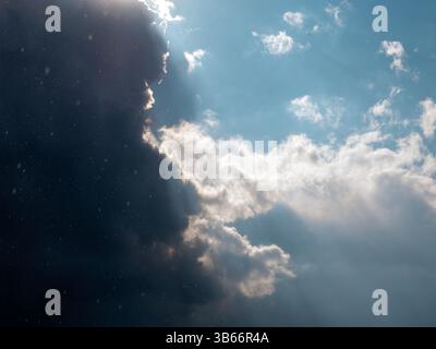 Cielo blu con nuvole bianche e puntini neri di uccelli che volano attraverso la finestra aperta. Foto Stock