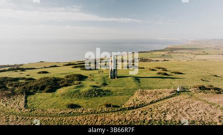 Un grande campo erboso con un piccolo edificio bianco nel mezzo. Il cielo è limpido e il sole splende Foto Stock