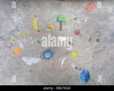 Disegni colorati in gesso realizzati dai bambini sul marciapiede. Opere d'arte luminose e giocose che mostrano creatività, immaginazione e la gioia del gioco all'aperto Foto Stock