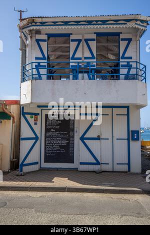 Deshaies, storici edifici in legno caraibici in una strada a Guadalupa, Caraibi, Antille francesi Foto Stock