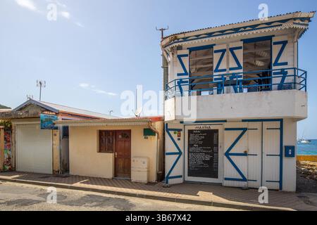Deshaies, storici edifici in legno caraibici in una strada a Guadalupa, Caraibi, Antille francesi Foto Stock