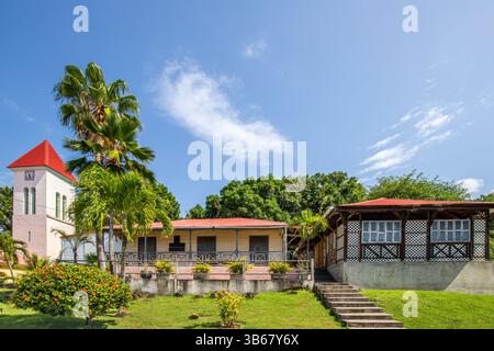 Deshaies, storici edifici in legno caraibici in una strada a Guadalupa, Caraibi, Antille francesi Foto Stock