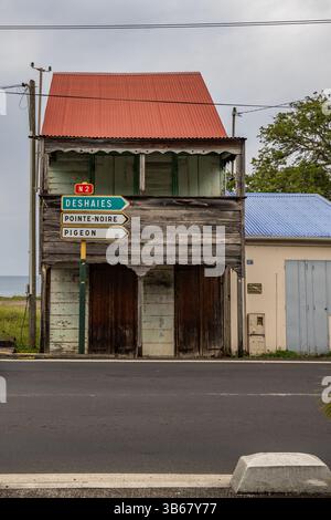 Deshaies, storici edifici in legno caraibici in una strada a Guadalupa, Caraibi, Antille francesi Foto Stock