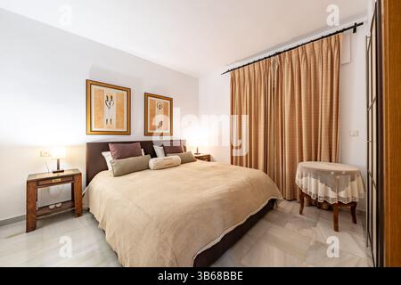 un'immagine di una camera da letto con un grande letto con vari cuscini nella casa vacanze Foto Stock