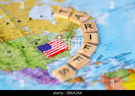 Una mappa degli Stati Uniti d'America e della bandiera americana con piastrelle di legno lettera che formano la parola tariffe. Un concetto di tariffe USA. Foto Stock