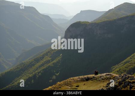 Due persone lontane che guardano il tramonto sul paesaggio montano dal punto panoramico di Lukomir, Bosnia ed Erzegovina (2 posti a sedere) Foto Stock
