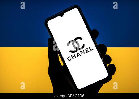 11 marzo 2022, Barcellona, Catalogna: In questa foto viene mostrato un logo Chanel visualizzato su uno smartphone con una bandiera dell'Ucraina sullo sfondo. (Immagine di credito: © Thiago Prudencio/DAX tramite ZUMA Press Wire) Foto Stock