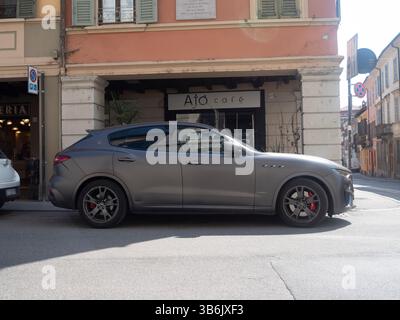 Cremona, Italia - 12 aprile 2025 elegante SUV Gray Maserati Levante Trofeo Parcheggio su una strada europea con edifici e architettura storica Evokin Foto Stock