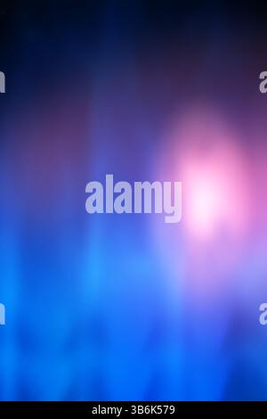 Sfondo blu e viola sfocato con una luce rosa al centro Foto Stock
