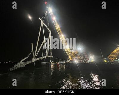 22 aprile 2024, Dundalk, MD, Stati Uniti d'America: Le chiatte di salvataggio rimuovono il relitto del Francis Scott Key Bridge crollato dal fiume Patapsco sul canale di Fort McHenry, 22 aprile 2024, vicino a Dundalk, Maryland. Il ponte è stato colpito dalla nave container MV Dali da 984 piedi il 26 marzo e crollò uccidendo sei lavoratori. (Immagine di credito: © po 2 Ronald Hodges/U.S. Coast/Planet Pix tramite ZUMA Press Wire) Foto Stock