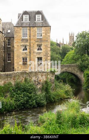 Vista panoramica dello storico Dean Village con il suo vecchio ponte in pietra sull'acqua di Leith a Edimburgo, Scozia, caratterizzato da un tradizionale edificio in pietra Foto Stock