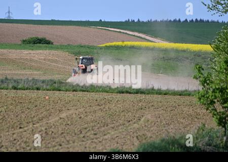 Themenbild Duerre: Anhaltende Trockenheit- Gefahr einer neuen Duerre waechst. Ein Traktor mit Egge, Pflug zerkleinert auf einem Acker bei anhaltender Trockenheit Erdschollen-es staubt, Staub. *** Quadro tematico siccità persistente pericolo di una nuova siccità sta crescendo Un trattore con erpice,aratro frantuma mantelli di terra in un campo in siccità persistente polveri,polvere Foto Stock