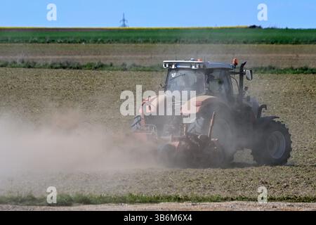 Themenbild Duerre: Anhaltende Trockenheit- Gefahr einer neuen Duerre waechst. Ein Traktor mit Egge, Pflug zerkleinert auf einem Acker bei anhaltender Trockenheit Erdschollen-es staubt, Staub. *** Quadro tematico siccità persistente pericolo di una nuova siccità sta crescendo Un trattore con erpice,aratro frantuma mantelli di terra in un campo in siccità persistente polveri,polvere Foto Stock