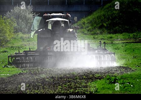 Themenbild Duerre: Anhaltende Trockenheit- Gefahr einer neuen Duerre waechst. Ein Traktor mit Egge, Pflug zerkleinert auf einem Acker bei anhaltender Trockenheit Erdschollen-es staubt, Staub. *** Quadro tematico siccità persistente pericolo di una nuova siccità sta crescendo Un trattore con erpice,aratro frantuma mantelli di terra in un campo in siccità persistente polveri,polvere Foto Stock