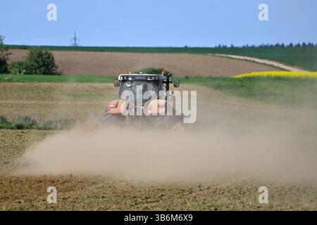 Themenbild Duerre: Anhaltende Trockenheit- Gefahr einer neuen Duerre waechst. Ein Traktor mit Egge, Pflug zerkleinert auf einem Acker bei anhaltender Trockenheit Erdschollen-es staubt, Staub. *** Quadro tematico siccità persistente pericolo di una nuova siccità sta crescendo Un trattore con erpice,aratro frantuma mantelli di terra in un campo in siccità persistente polveri,polvere Foto Stock