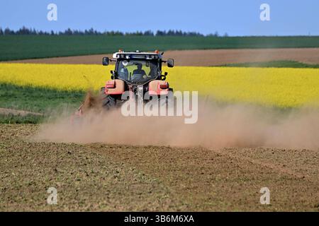 Themenbild Duerre: Anhaltende Trockenheit- Gefahr einer neuen Duerre waechst. Ein Traktor mit Egge, Pflug zerkleinert auf einem Acker bei anhaltender Trockenheit Erdschollen-es staubt, Staub. *** Quadro tematico siccità persistente pericolo di una nuova siccità sta crescendo Un trattore con erpice,aratro frantuma mantelli di terra in un campo in siccità persistente polveri,polvere Foto Stock