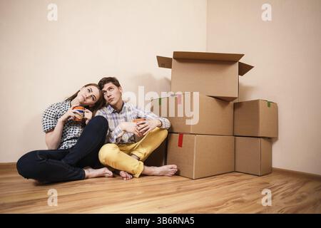 Giovane coppia con scatole di caffè nel nuovo appartamento Foto Stock