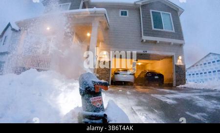 Attività di sgombero delle nevi serali in un accogliente quartiere residenziale Foto Stock