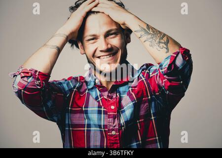 Ritratto alla moda di un bell'uomo con acconciature alla moda in una camicia elegante su sfondo verde chiaro, Toronto, Canada, Nord America Foto Stock