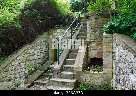 Storico misuratore del livello dell'acqua vicino al fiume Ohře, città di Louny, Cechia. Ci sono scale e un muro con le scale. Foto Stock