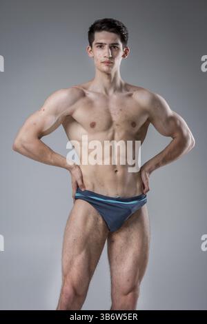 Ritratto in studio giovane uomo caucasico su sfondo grigio in posa. tema della pubertà, pelle problematica, acne adolescente. Atleta caucasico fitness allergia sport noce Foto Stock
