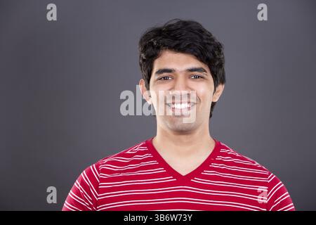 Bell'uomo dell'india orientale che indossa una camicia rossa su sfondo grigio chiaro, Toronto, Canada, Nord America Foto Stock