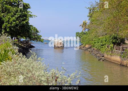 Bocca del fiume a Galle Sri Lanka con vegetazione tropicale e ponte bianco rotto verso l'oceano durante il giorno Foto Stock