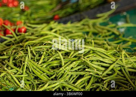 Una pila di fagioli verdi crudi esposti in un mercato ortofrutticolo Foto Stock