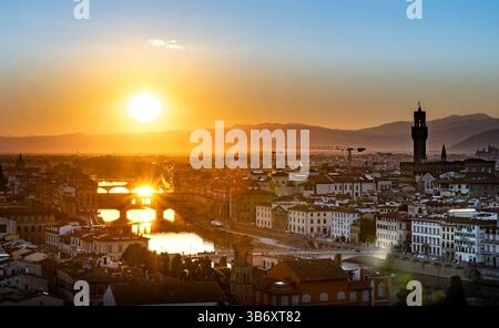 Un tramonto mozzafiato su Firenze, Italia, che mostra il fiume Arno e l'architettura storica. Il sole proietta un bagliore dorato che illumina la citysca Foto Stock