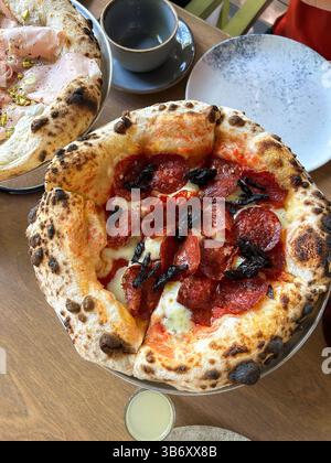 Pizza classica con impasto sottile e arioso con salsa di pomodoro fresca e formaggio fuso servita al ristorante Foto Stock