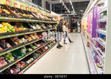 Due clienti che fanno acquisti in frutta e verdura fresca al supermercato Sainsbury's London UK Foto Stock