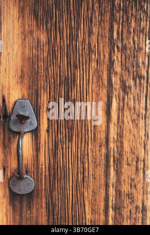 Porta in legno vintage con maniglia in metallo invecchiato e superficie ruvida. Foto Stock