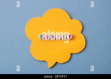 Bolla vocale con la parola "Survey", perline circolari bianche con lettere colorate su una nota adesiva Foto Stock