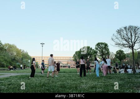 persone che giocano e si rilassano nel parco verde pubblico sotto il cielo limpido nelle giornate di sole in primavera. Foto di alta qualità Foto Stock