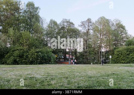 persone che giocano e si rilassano nel parco verde pubblico sotto il cielo limpido nelle giornate di sole in primavera. Foto di alta qualità Foto Stock