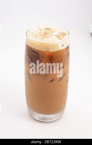 caffè ghiacciato con crema e cubetti di ghiaccio servito in alto vetro trasparente con la parte superiore schiumosa fotografata su sfondo bianco. Foto di alta qualità Foto Stock