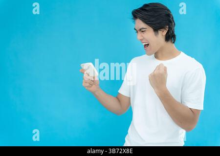 Asiatico bello uomo uscito sorpresa faccia espressione . Gli uomini si sentono scioccati dal telefono. sorrisi entusiasmanti e allegre adorabili gioie. Molto divertente e divertente Foto Stock