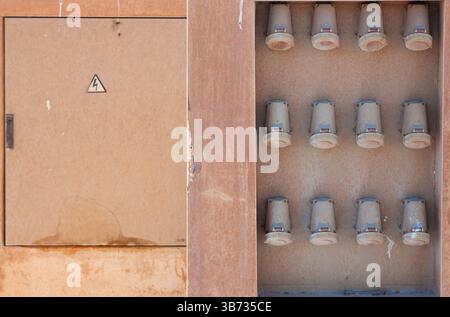File di prese elettriche industriali vicino al quadro elettrico. Prese per porte ad alta tensione. Foto Stock