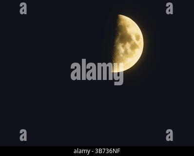 Mezza luna nel cielo notturno. Superficie lunare dettagliata, tema astronomia e esplorazione spaziale, corpo celeste nell'oscurità, scena spaziale esterna tranquilla, perfetta per i concetti di scienza e natura. Fotografia di scorta Foto Stock