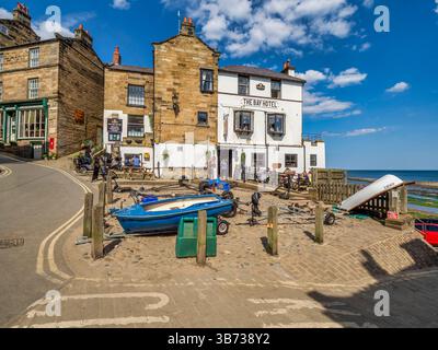 Robin Hoods Bay, il Bay Inn, in una calda giornata estiva, una coppia che entra dall'entrata. Foto Stock