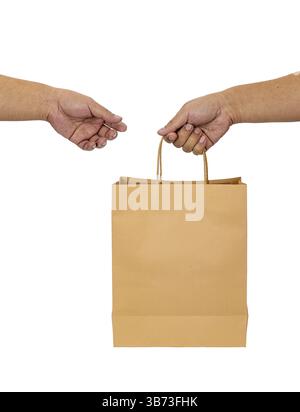 Un sacchetto di carta marrone a due mani che simboleggia la transazione o la consegna. l'immagine cattura il momento del trasferimento su sfondo bianco semplice, enfasi Foto Stock