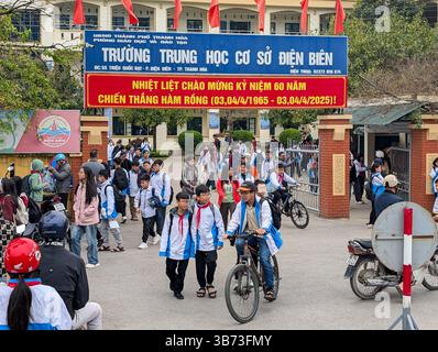 Gli studenti di una scuola media a Thanh Hoa, Vietnam, il 18 marzo 2025 lasciano la scuola dopo le lezioni. Gli alunni sono vestiti con uniformi bianche e blu. Foto Stock