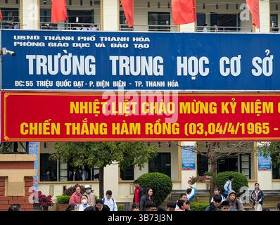Gli studenti di una scuola media di Thanh Hoa, Vietnam, lasciano le loro classi dopo le lezioni il 18 marzo 2025, l'ingresso della scuola è abbellito da un divieto Foto Stock