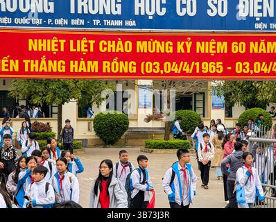 Gli studenti di una scuola media di Thanh Hoa, Vietnam, lasciano le loro classi dopo le lezioni il 18 marzo 2025, l'ingresso della scuola è abbellito da un divieto Foto Stock