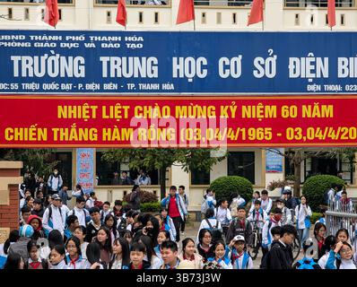 Gli studenti di una scuola media di Thanh Hoa, Vietnam, lasciano le loro classi dopo le lezioni il 18 marzo 2025, l'ingresso della scuola è abbellito da un divieto Foto Stock