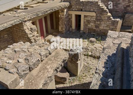 I turisti esplorano i resti del Palazzo di Cnosso, osservando gli elementi architettonici che narrano l'eredità dell'antica Grecia. Foto Stock