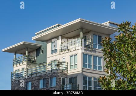 Moderno complesso di condomini. Nuova casa cittadina con belle finestre. Dormer con sfondo blu. Facciata di casa moderna. Esterno Immobiliare p. Foto Stock