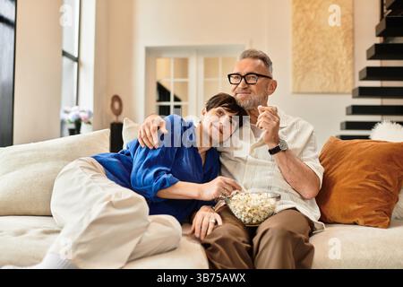 Questa coppia gioiosa sta condividendo una deliziosa serata insieme, rilassandosi a casa. Foto Stock
