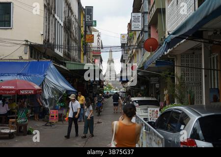 Bangkok, Thailandia. 5 maggio 2025. Un turista che scatta foto della grande Pagoda di Wat Arun da un vicolo fuori Wat Pho. Alla fine di aprile 2025, gli arrivi di turisti stranieri in Thailandia sono diminuiti drasticamente, in particolare tra i turisti cinesi, da una media di 15.000-20.000 a 5.000 persone al giorno a causa della diminuzione della fiducia nella sicurezza della Thailandia. Crediti: Watcharawit Phudork/Alamy Live News Foto Stock